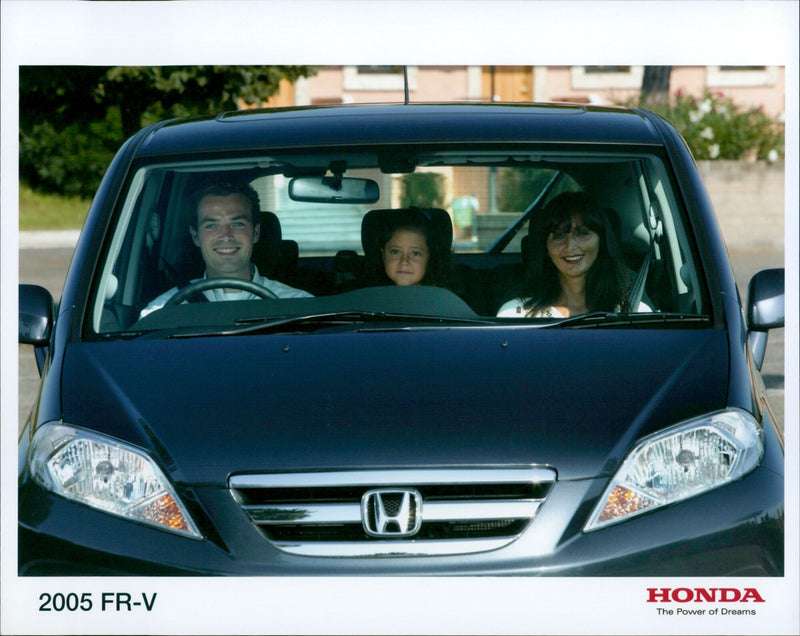A man admires a 2005 Honda FR-V H, one of the first models released under the company's "The Power of Dreams" slogan. - Vintage Photograph