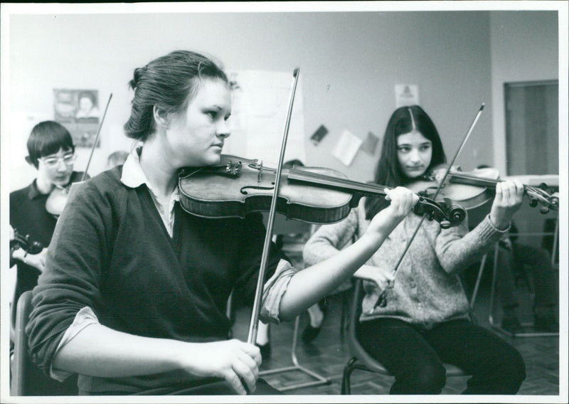 Two violinists concentrate on their music lesson. - Vintage Photograph