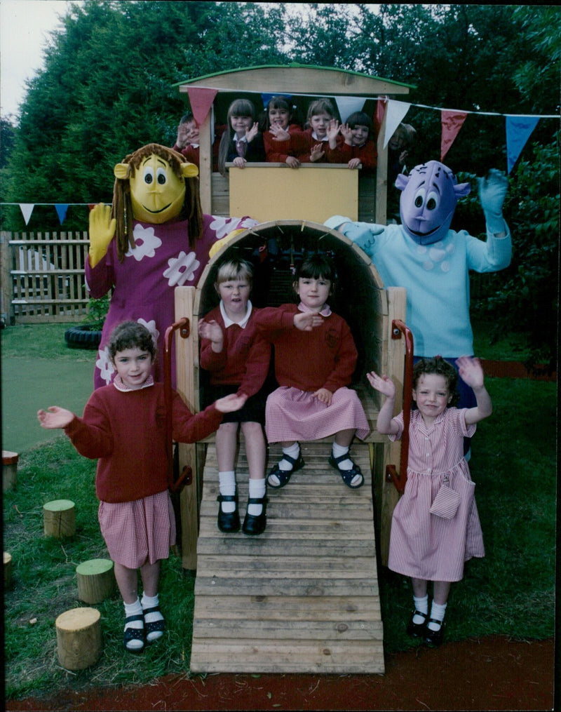 Milo and Fizz from the TV show The Tweenies celebrate with parents and other Launton Primary School students after raising £2,000 for a train engine for the school playground. - Vintage Photograph