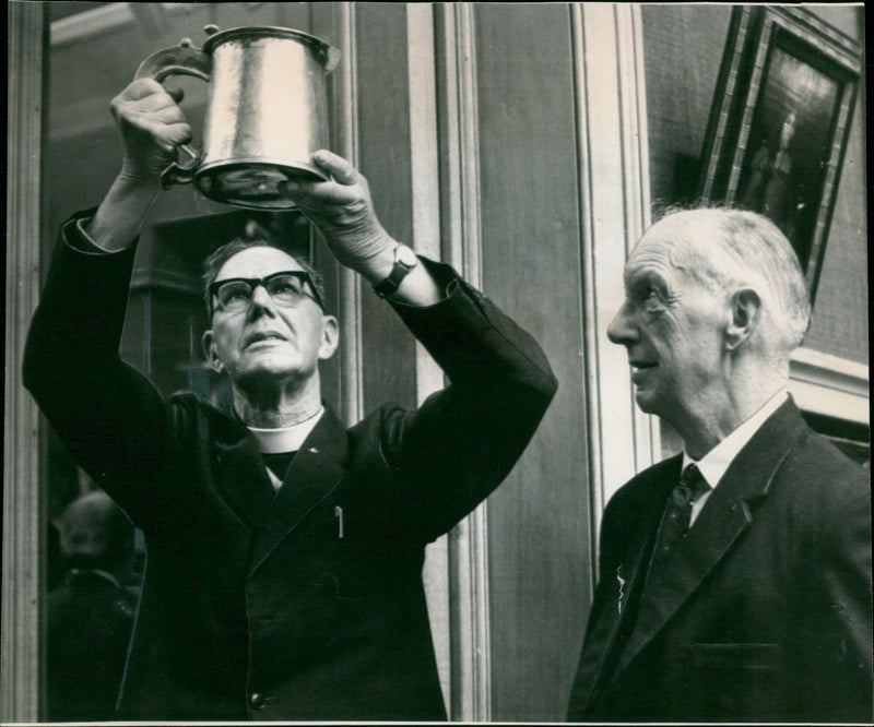 The Rev. Frank Taylor and Mr. Jack Wing, churchwarden, take a last look at the Lambourn Tankard after its sale at Christie's. - Vintage Photograph