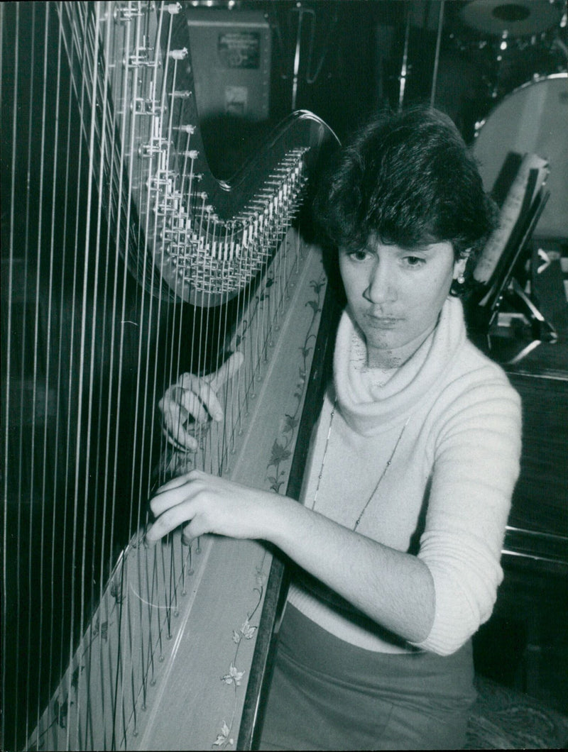 Musician Sosband Marie Beattie plays the harp. - Vintage Photograph