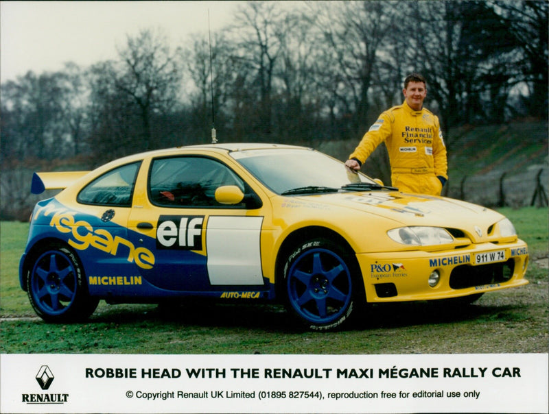 Robbie Head poses with a Renault Maxi Mégane rally car. - Vintage Photograph