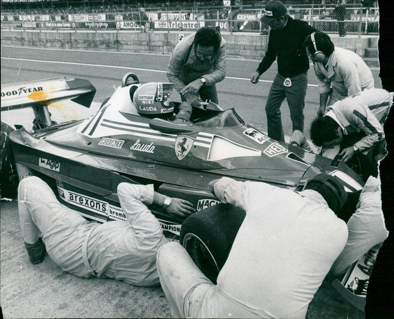Mechanics work on a Ferrari in preparation for a race. - Vintage Photograph