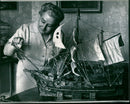 Mrs. Mary McNeill dusts a matchstick model of an old galleon. - Vintage Photograph