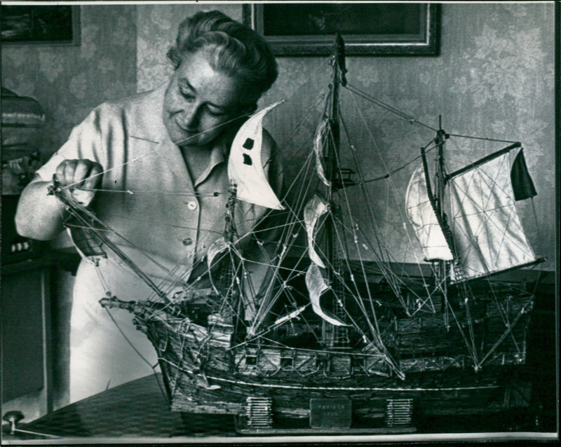 Mrs. Mary McNeill dusts a matchstick model of an old galleon. - Vintage Photograph