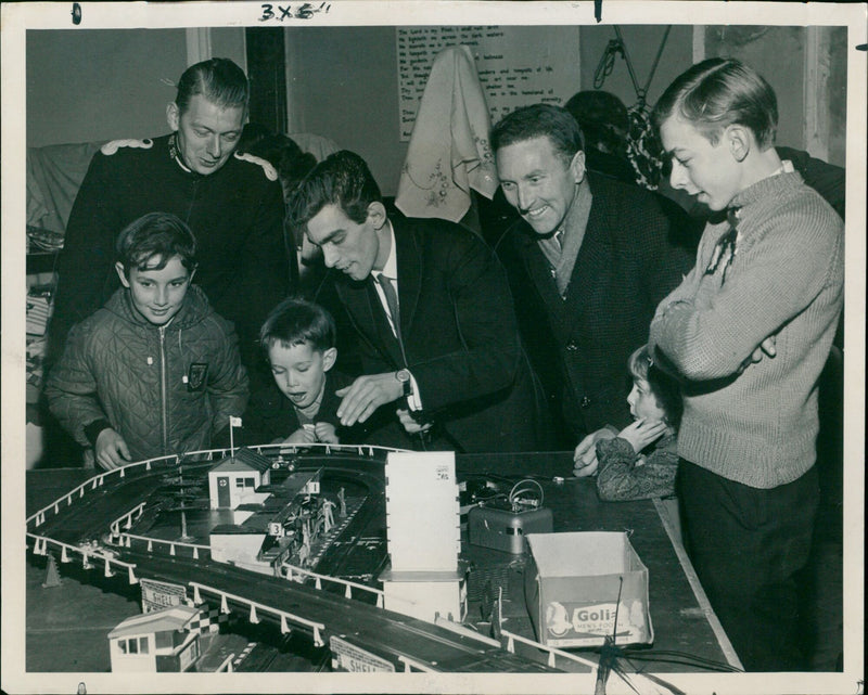 Boys and their fathers enjoy a model racing car circuit at Banbury Salvation Army's fair. - Vintage Photograph