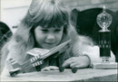 Janine Wheeler (8) of Kidlington celebrates winning a slot-together balsa wood and rubber powered plane model competition. - Vintage Photograph