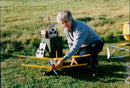 Garnet Hurst Lymbrook, founder of the Model-Aero Club, poses with a "Aero" 13 DFC 1995 model aircraft in Shelses, 1995. - Vintage Photograph