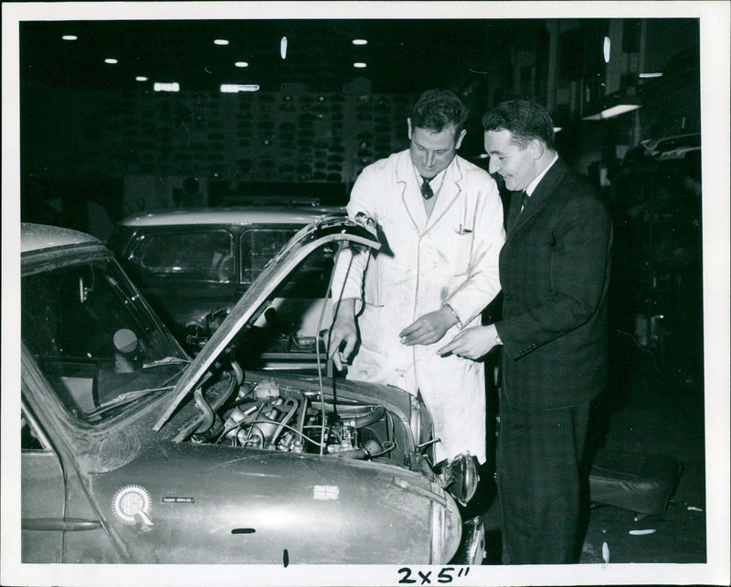 Paddy Hopkirk discussing engine details with Mr. Douglas Watts at M.G. Abingdon. - Vintage Photograph
