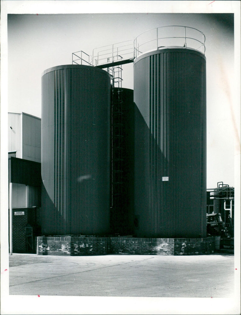 Two stainless steel silos and a bulk water tank in glass reinforced plastic at DANGER CURY's County Dairies in Oxford. - Vintage Photograph