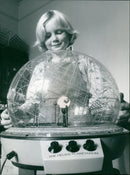 Phoebe Cochrane views the model planetarium at the Helios Planetarium. - Vintage Photograph