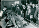Model railway enthusiasts operate a layout at a model train exhibition. - Vintage Photograph