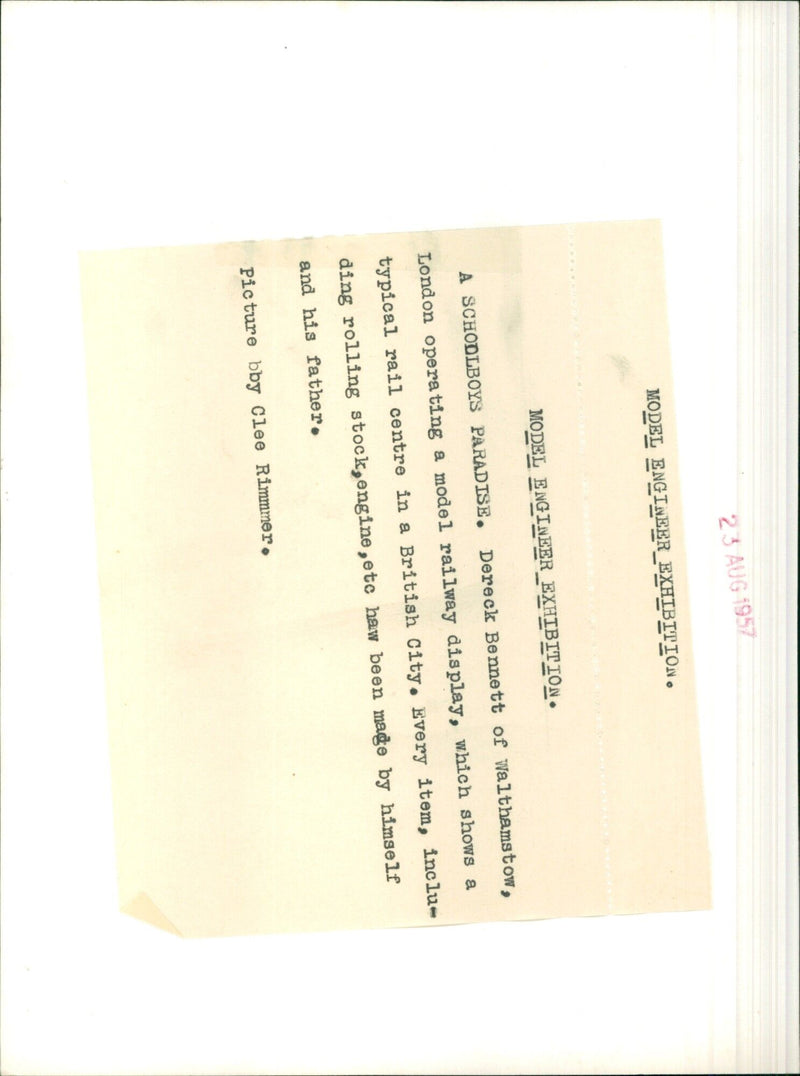 A young boy operates a model railway display depicting a British rail center. - Vintage Photograph