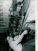 A young boy operates a model railway display depicting a British rail center. - Vintage Photograph