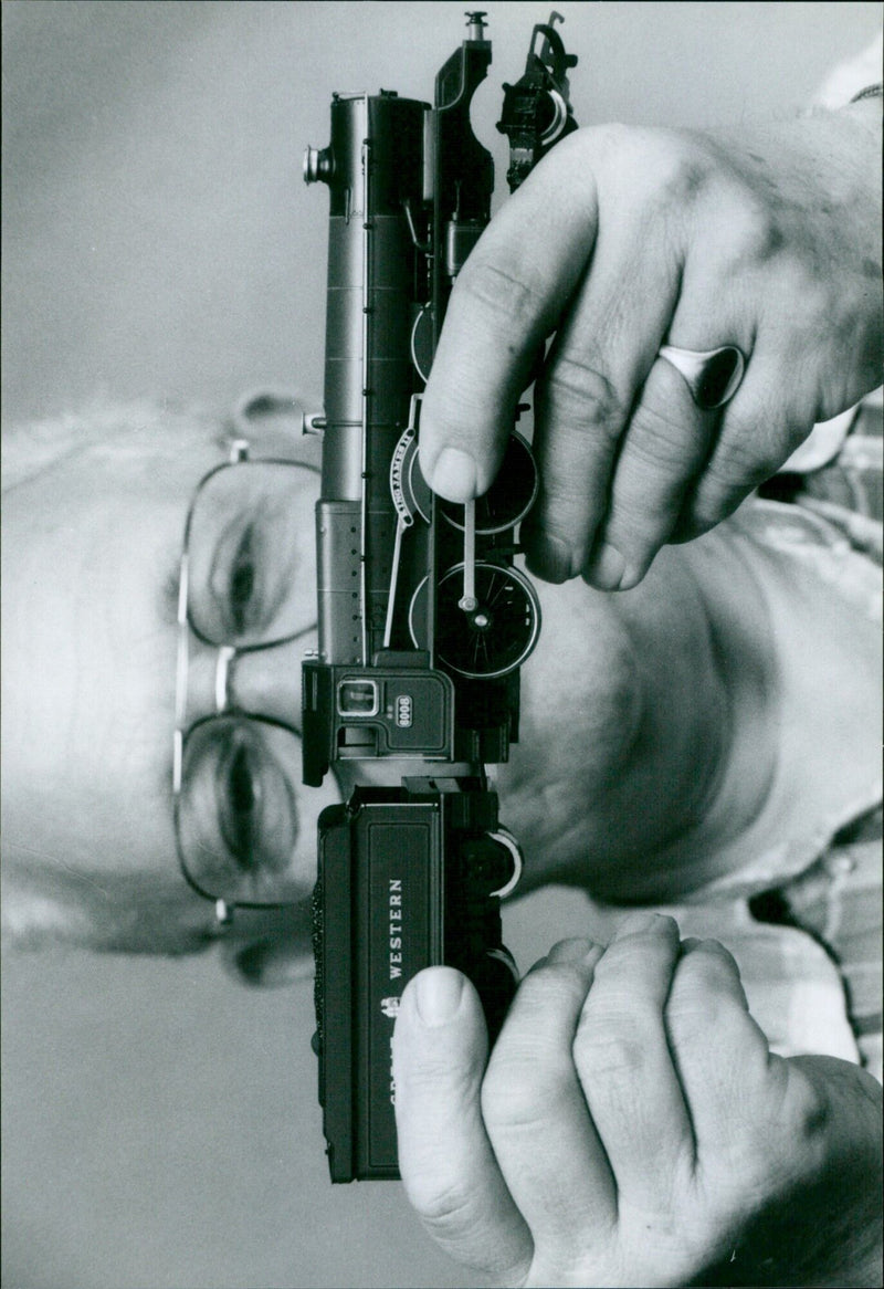 Doug Eeles poses with a model of a Great Western Engine and a model Traus Care. - Vintage Photograph