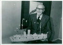 Dick Clarke of West End, Launton, poses with a matchstick model of an armoured merchantman which he made in October 1983. - Vintage Photograph