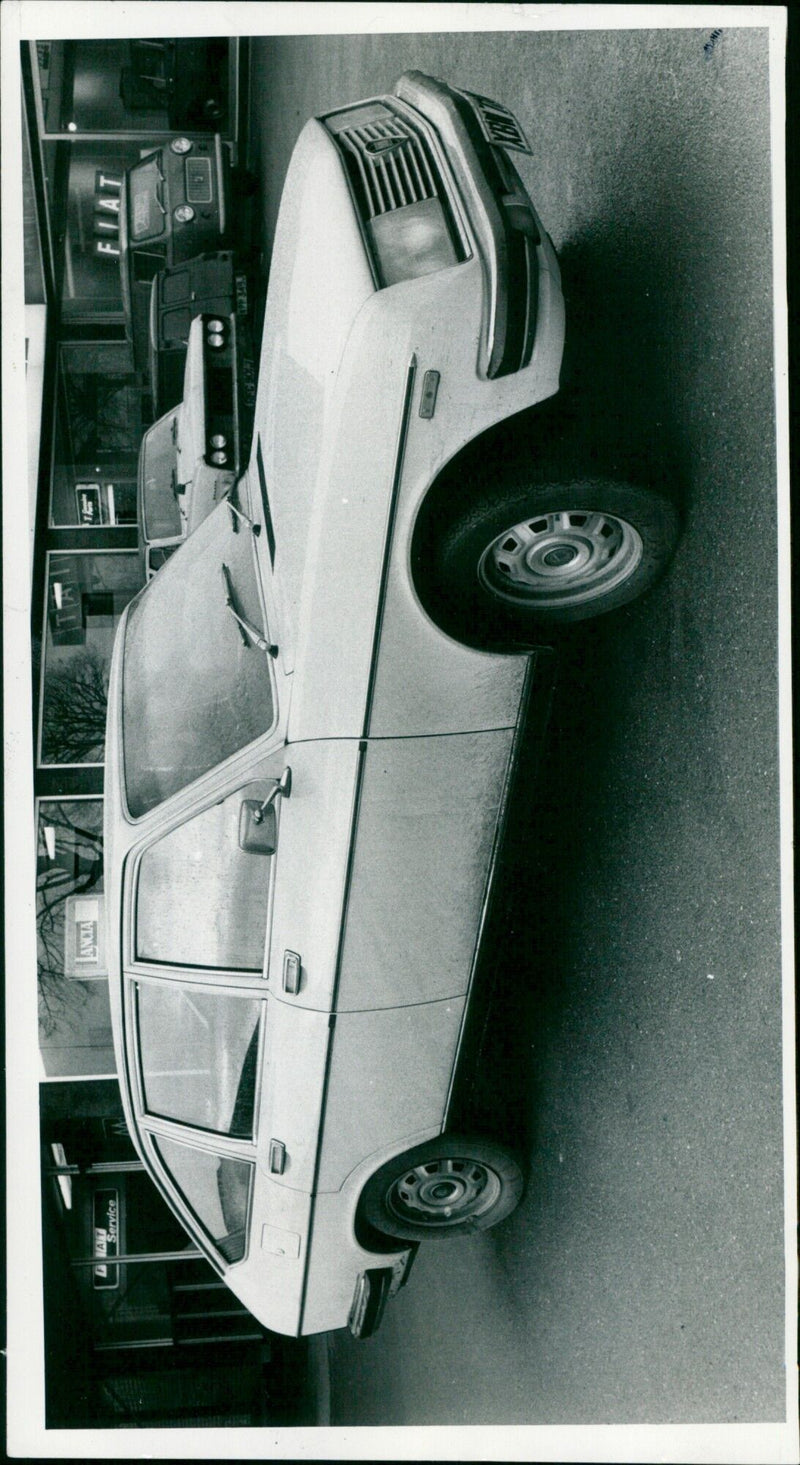 A Fiat 1600 sedan at a service station. - Vintage Photograph