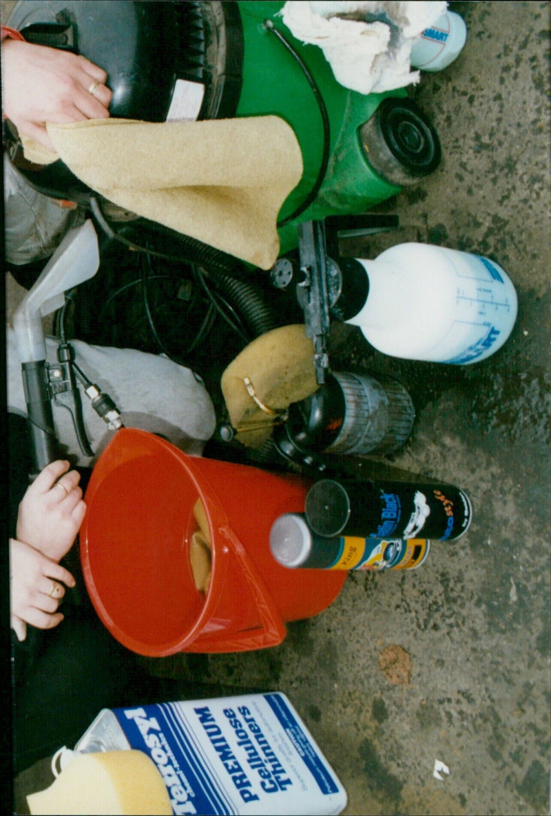 A man wearing a safety helmet applies terrosy cellulose thinners to a car in a valeting garage. - Vintage Photograph