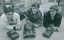 Fifteen-year-olds Richard Peverell and Michael Huggins inspect scaled-down models of heavy weapons alongside Army Trooper Clive Russell. - Vintage Photograph