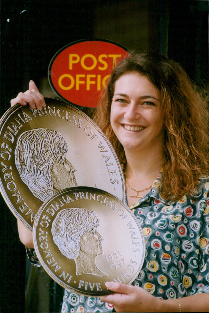 Manager Sonia Cunnane holds a "giant" gold coin commemorating Princess Diana. - Vintage Photograph