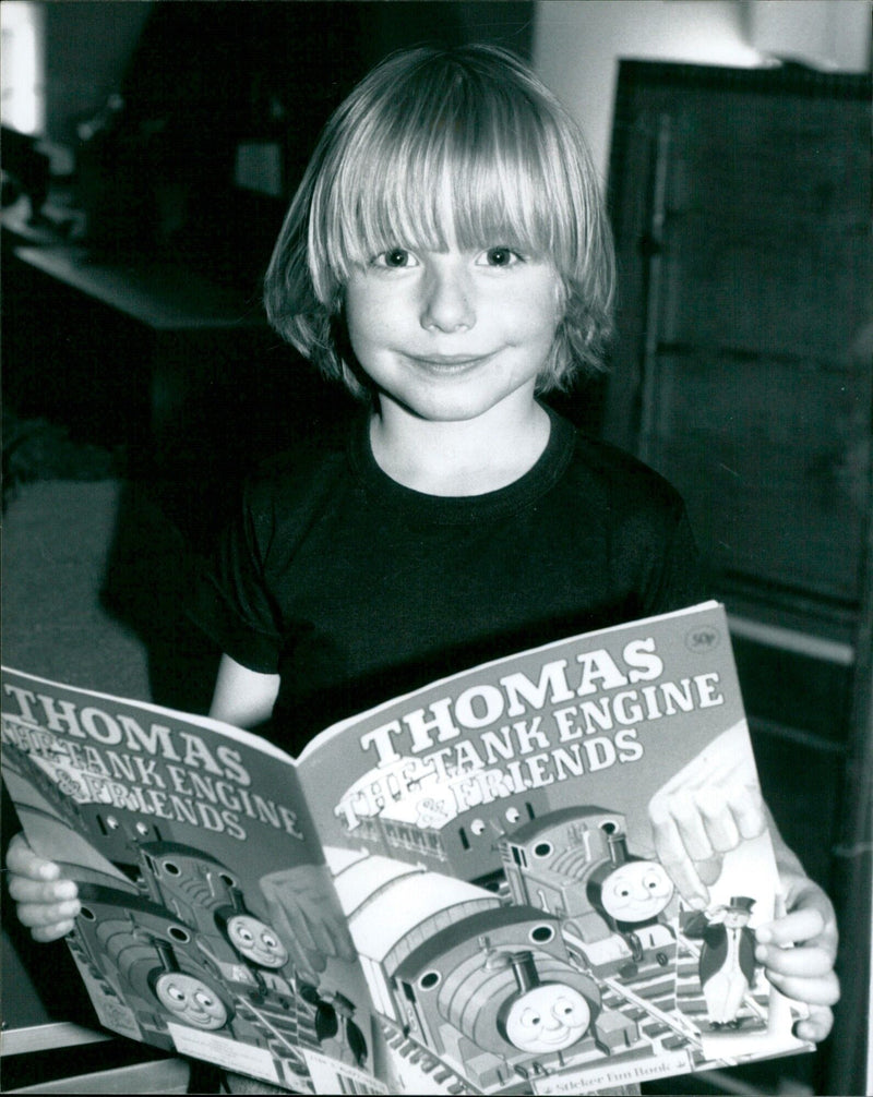 Four-year-old Keir Thomas enjoys a good story about Thomas the Tank Engine at the Abingdon and District Model Railway Club exhibition. - Vintage Photograph
