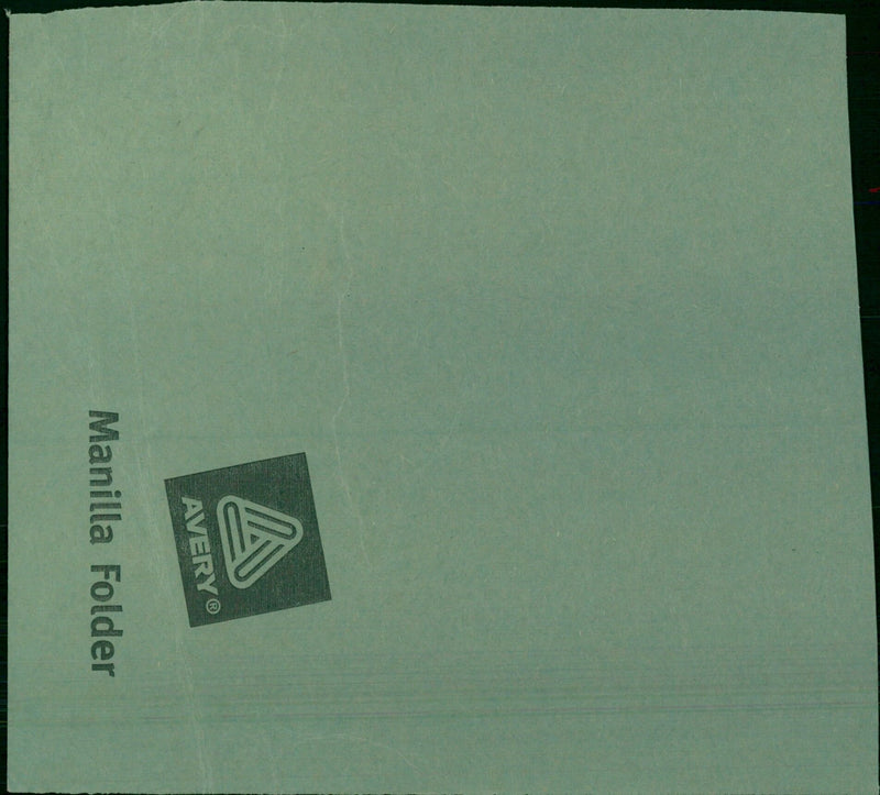 A model train set is displayed inside a closed Avery™ manilla folder. - Vintage Photograph