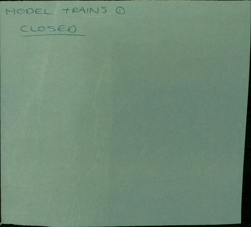 A model train set is displayed inside a closed Avery™ manilla folder. - Vintage Photograph