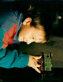 Simon Twitchen (8) inspects a model railway purchased with his Christmas money. - Vintage Photograph