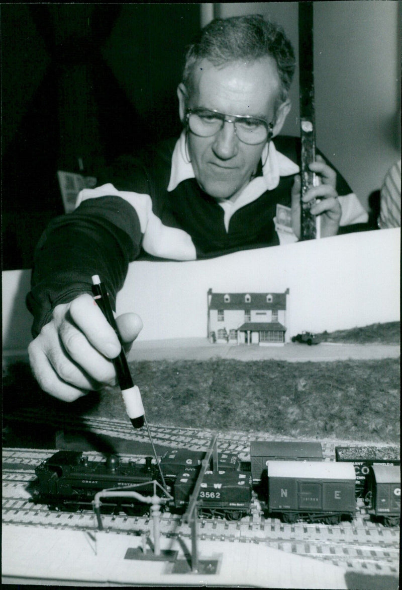 A model locomotive is uncoupled from a train at the Model Rail Exhibition in Abbey Hall, Abingdon. - Vintage Photograph