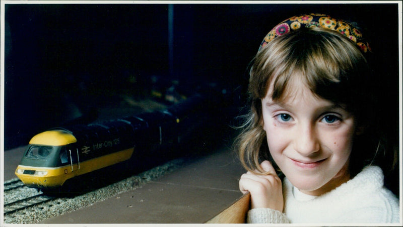 Six-year-old Jennifer Gough poses with a model high speed train at the Model Train Fair at Exeter Hall Kidlington. - Vintage Photograph