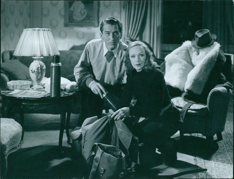 A group of nine people gather around a bonfire during the premiere of the Swedish film "Del brinner en eld" in 1944. - Vintage Photograph