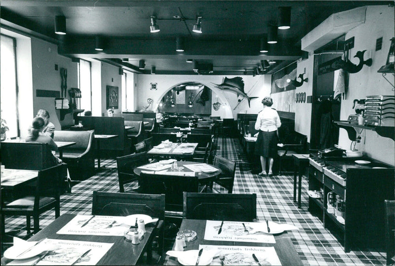 Chefs at Sturehofs Fiskkrog in Stockholm plate a traditional Swedish dish of herring, potatoes and onions while wearing the restaurant's iconic blue and white striped aprons. - Vintage Photograph