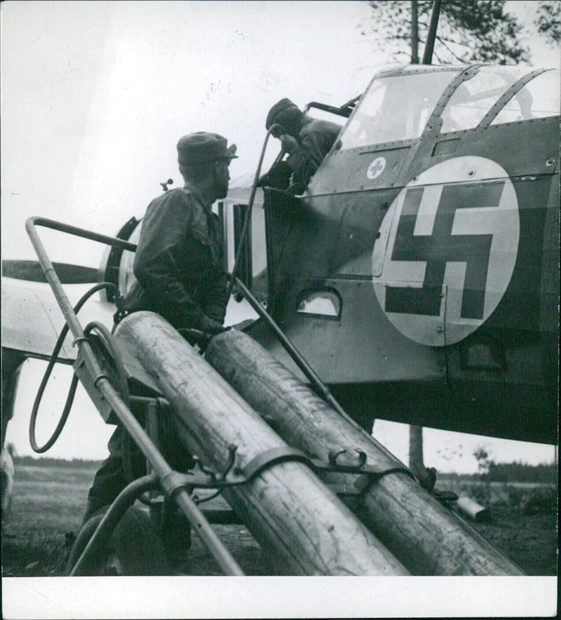 A group of Finnish soldiers equipped with a Se 32 fighter plane and a Hyunding land plane flying over the landscape in 1941. - Vintage Photograph