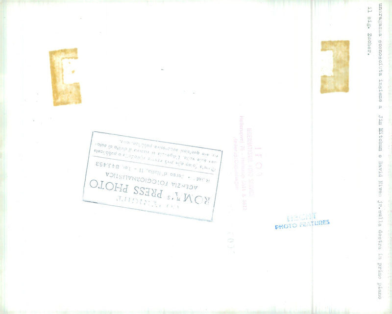 Jim Mitchum e David Niven Jr. sono ritratti insieme a una ragazza sconosciuta e al sig. Zucher in una scena di un film del 1976. - Vintage Photograph