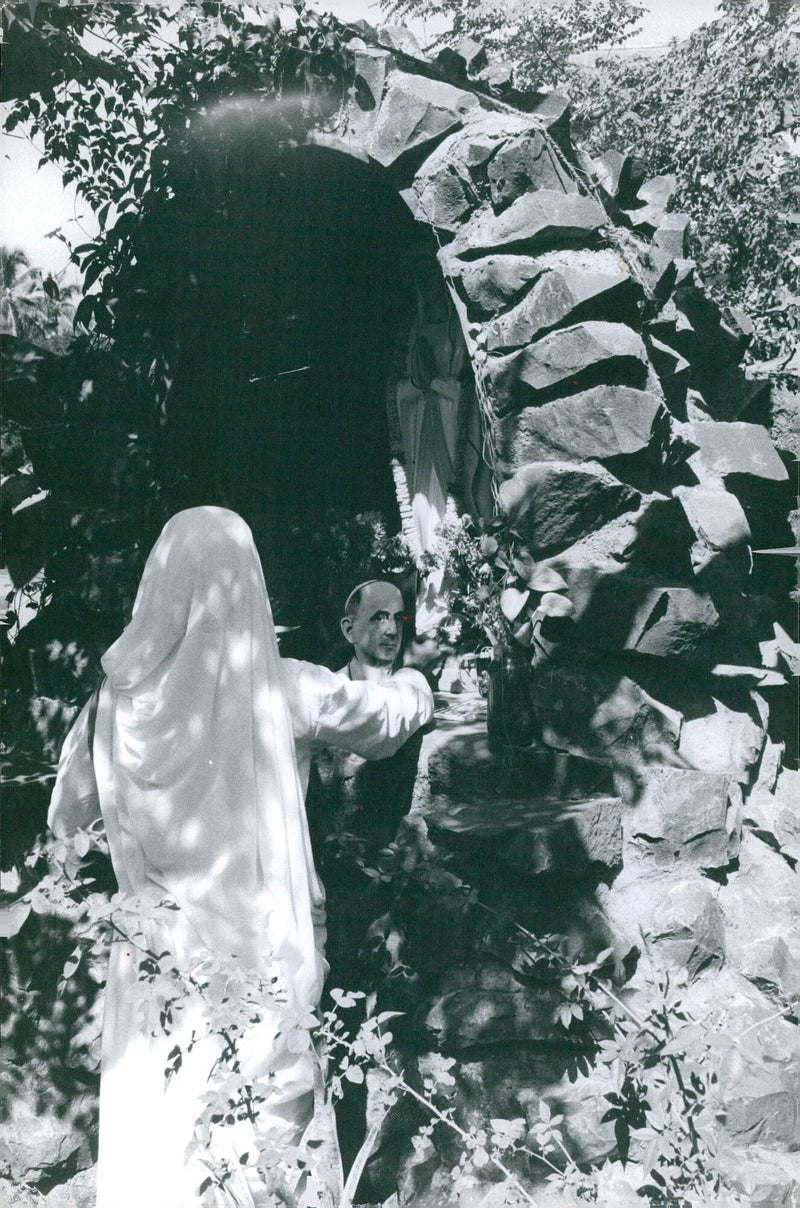 A crowd of people can be seen gathering outside the Laver Iludière 12 AYENUE FROCHOT in Paris, France on a sunny day. - Vintage Photograph