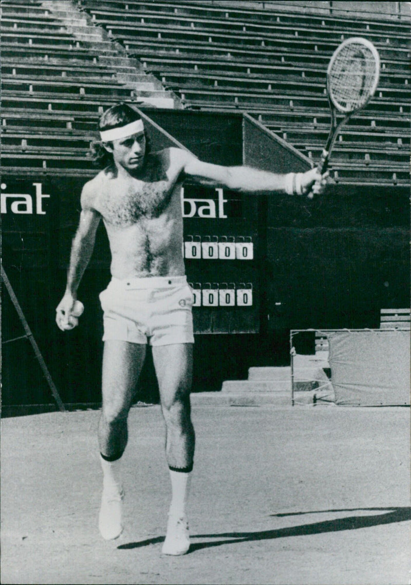 Argentine tennis legend Guillermo Vilas practices his strokes at an unknown location in 1977. - Vintage Photograph