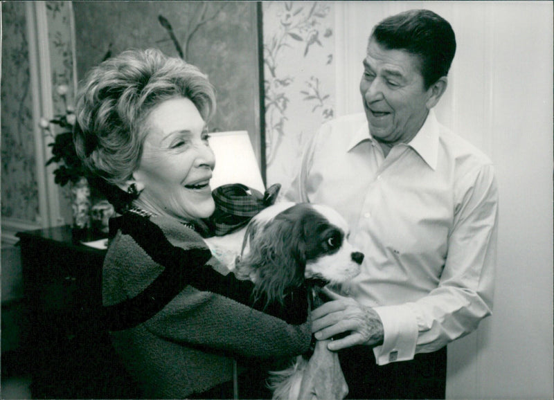 On December 25th 1986, First Lady Nancy Reagan gifts her husband President Ronald Reagan with a King Charles Spaniel puppy named Rex for Christmas. - Vintage Photograph