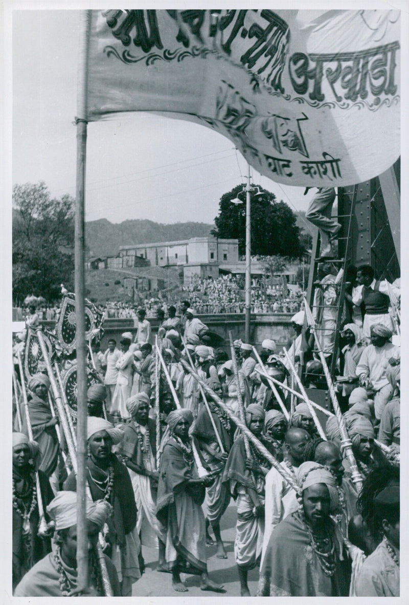 Thousands of worshippers take part in a seven-mile procession, displaying flags and spears in the traditional procession of the Akhada Panch Ghat Kashi in India. - Vintage Photograph