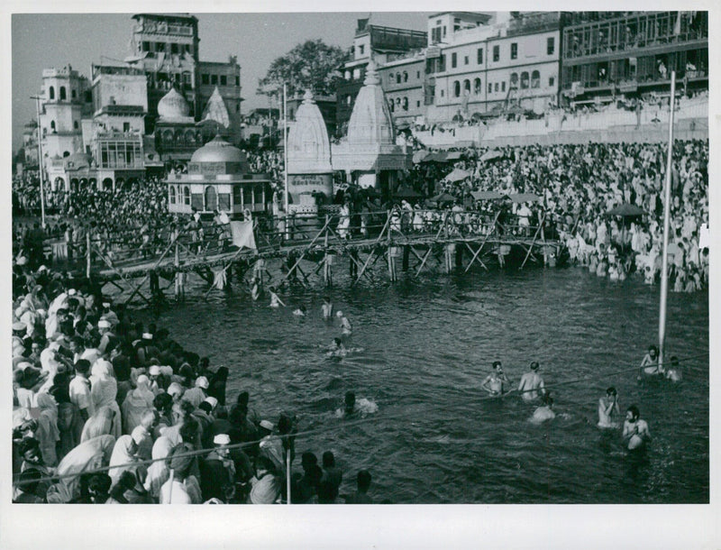 Thousands of people gather around the holy basin on the banks of the river in India, marking the completion of the bridges built by Indian pioneers. - Vintage Photograph