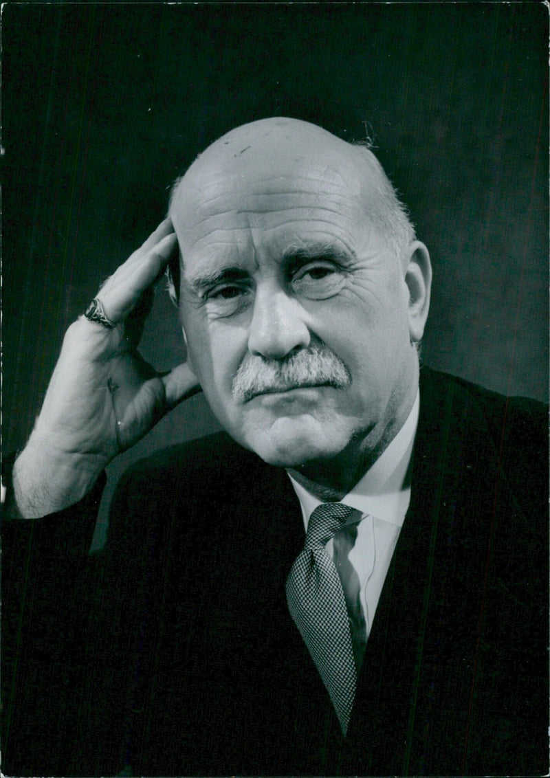 Sir Kenneth Grubb, Executive Trustee of the Survey Application Trust and President of the Church Missionary Society, poses for a portrait in 1960. - Vintage Photograph