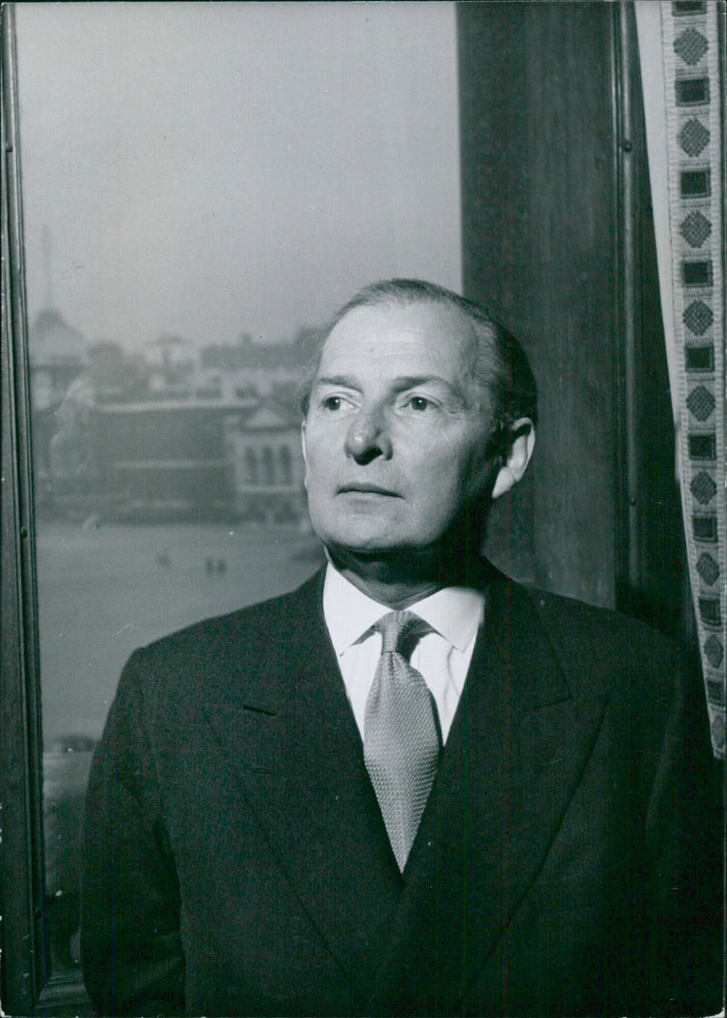 Britain's Foreign Secretary, The Rt Hon. Selwyn Lloyd, P.C., C.B.E., Q.C., M.P. poses in his office with the Admiralty building in Horse Guard's Parade seen through the window. Photo by Tom Blau. - Vintage Photograph