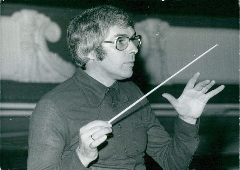 Iain Sutherland, conductor of the BBC Concert Orchestra, conducts a rehearsal in London, England, in 1975. - Vintage Photograph