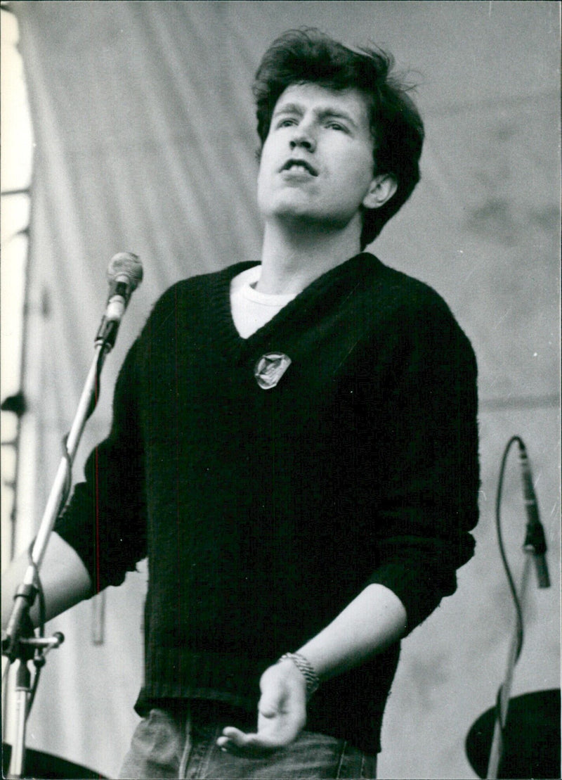 British singer Tom Robinson, leader of the Tom Robinson Band, performs onstage at a concert. - Vintage Photograph