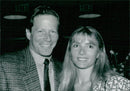 US actor Peter Strauss and his wife pose for a photograph in 1988. - Vintage Photograph