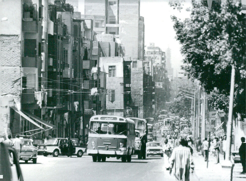 A bustling street scene in Cairo, Egypt, with the Sultan Hassan Mosque in the background. - Vintage Photograph