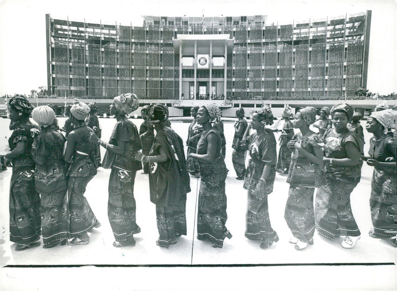 Dressed in traditional style, a troupe of Liberian dancers perform outside President William Tolbert's home and office in Monrovia, Liberia. - Vintage Photograph