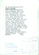 Singer/Songwriter Randy Newman poses with his guitar in 1985. - Vintage Photograph