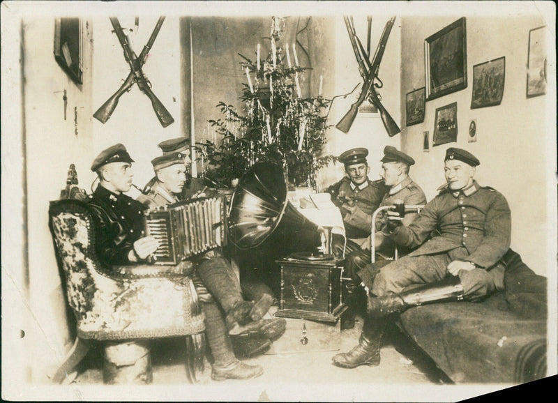 German soldiers celebrate Christmas with a festive gathering in their eastern front quarters during WWI, 1916. - Vintage Photograph
