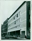 A group of police officers stand in front of a house on Tuesday, October 29, 1957. - Vintage Photograph