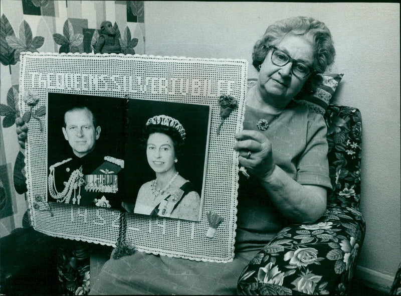 Queen Elizabeth II smiles as she receives a gift during her Silver Jubilee tour of Miva County, West Los. - Vintage Photograph